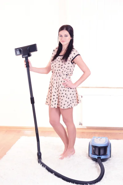 Belle jeune femme avec aspirateur dans la chambre — Photo