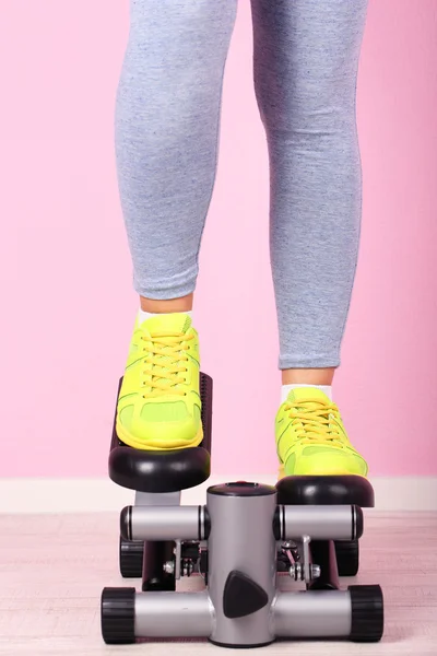 Woman doing exercise on stepper. Close-up on legs. — Stock Photo, Image