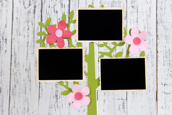 Supporto in forma di albero con schede fotografiche istantanee su sfondo di legno a colori — Foto Stock