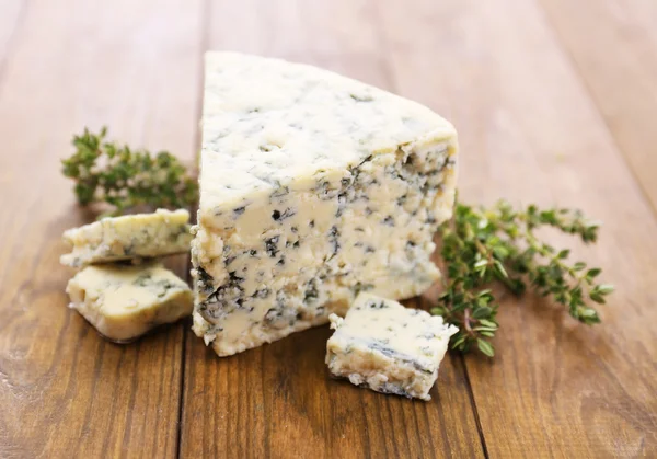 Smakelijke blauwe kaas met tijm, op houten tafel — Stockfoto