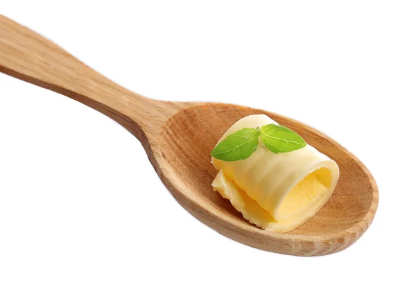 Curl of fresh butter with basil on wooden spoon, isolated on white — Stock Photo, Image