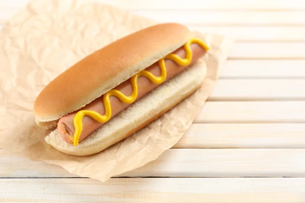 Sabroso perrito caliente en mesa de madera — Foto de Stock