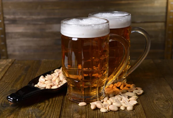 Glasses of beer with snack on table on wooden background — Stock Photo, Image