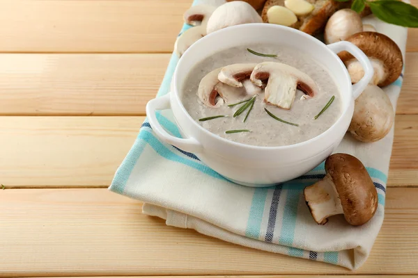 Sopa de champiñones en olla, en servilleta de color, sobre fondo de madera —  Fotos de Stock