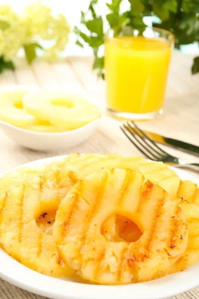 Sappige Gegrilde ananas op plaat op tabel close-up — Stockfoto