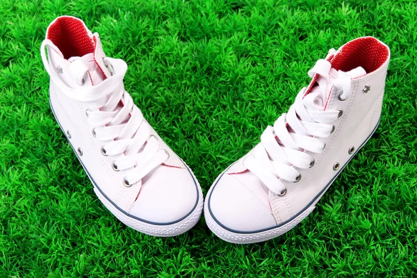 Belle scarpe da ginnastica su sfondo erba verde — Foto Stock