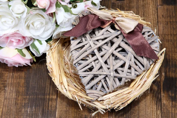 Corazón decorativo en el nido, sobre fondo de madera de color — Foto de Stock
