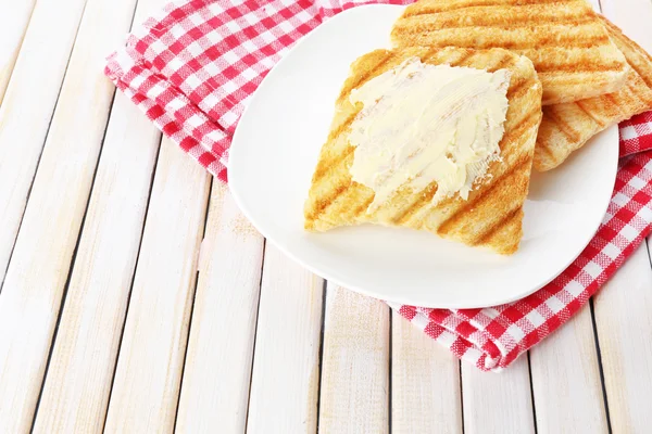 Grillat bröd med smör på träbord — Stockfoto