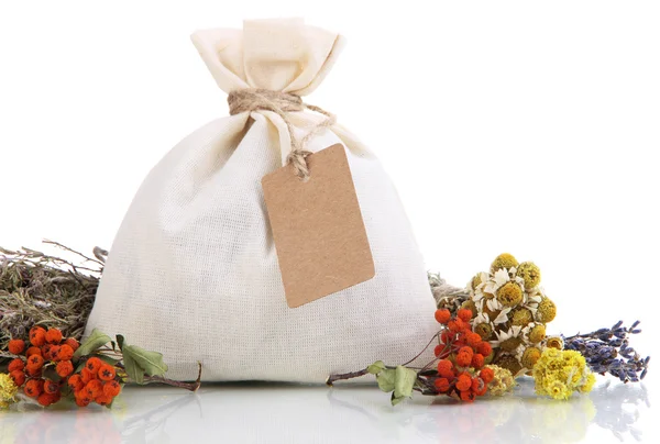 Bolsa de saqueta têxtil com flores secas, ervas e bagas, isolada em branco — Fotografia de Stock