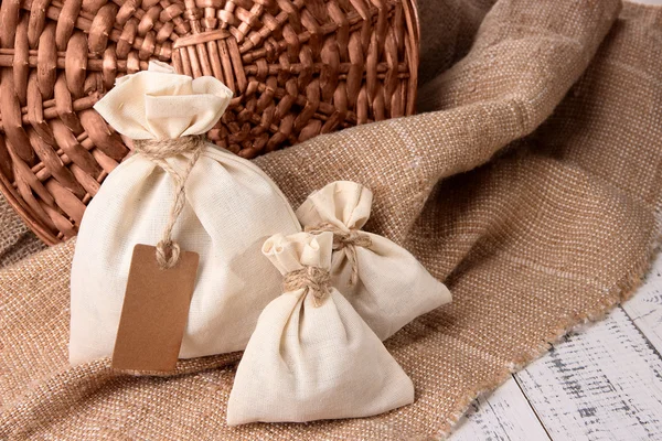 Jute bags on sackcloth, on wooden background — Stock Photo, Image