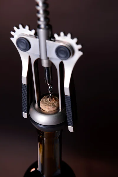 Corkscrew with bottle of wine on wooden background — Stock fotografie