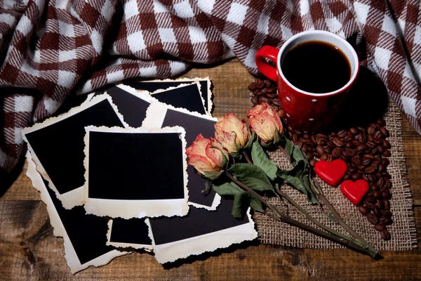 Kompozycja z filiżanki kawy, ozdobny serca, pled przyprawy i stare zdjęcia puste, na tle drewniane — Zdjęcie stockowe