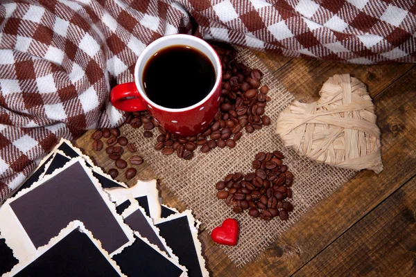 Composition with coffee cup, decorative hearts, plaid spices and old blank photos, on wooden background — Stock Photo, Image