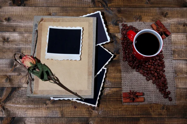 Sammansättning med kaffe kopp och foto album, på trä bakgrund — Stockfoto