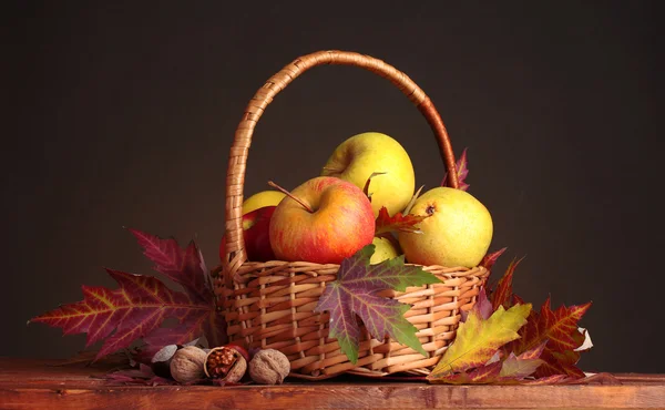 Hermosa cosecha de otoño en cesta y hojas sobre fondo marrón — Foto de Stock