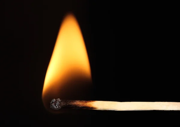 Burning match on black background — Stock Photo, Image