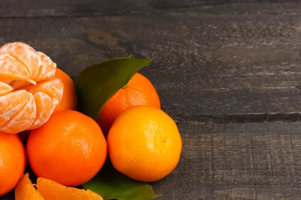 Mandarinen mit Blättern auf grauem Holztisch — Stockfoto