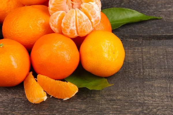 Mandarijnen met bladeren op houten grijs tafel — Stockfoto