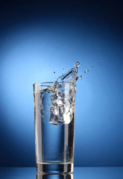 Agua dulce en vaso con cubitos de hielo sobre fondo azul — Foto de Stock