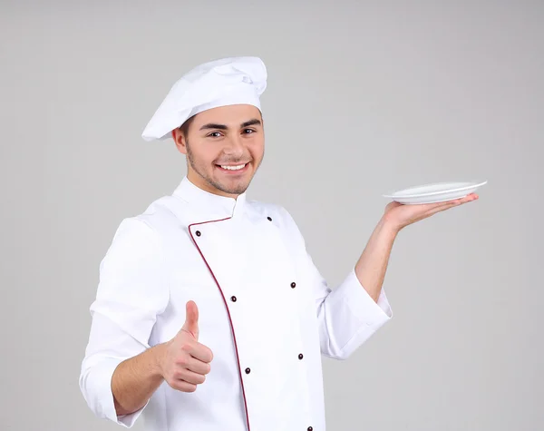 Chef profissional em uniforme branco e chapéu, em fundo cinza — Fotografia de Stock