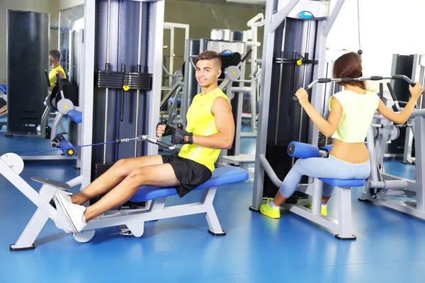Facet i dziewczyna zaangażowana w symulatorze siłowni — Zdjęcie stockowe