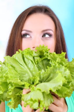 Mavi zemin üzerine taze salata ile güzel kız