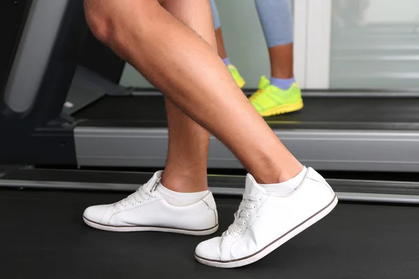 Femmes et hommes pieds sur tapis roulant close-up — Photo