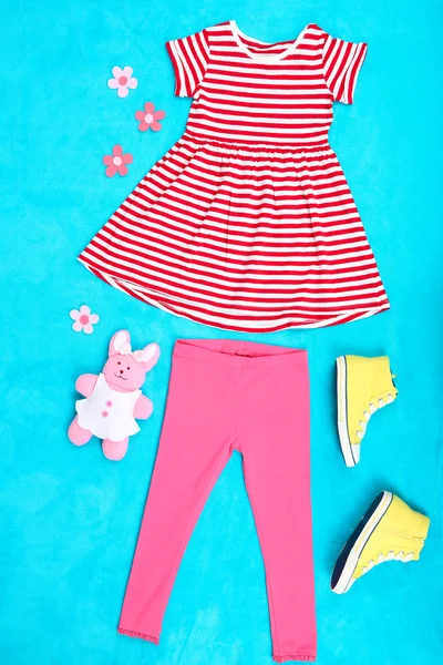 Beautiful clothes for little girl on blue background — Stock Photo, Image