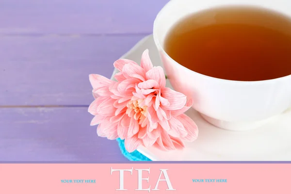 Розовый хризантема и чашка чая на деревянном столе — стоковое фото