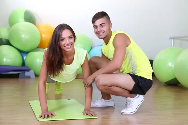 Girl and trainer engaged in fitness room — Stock Photo, Image