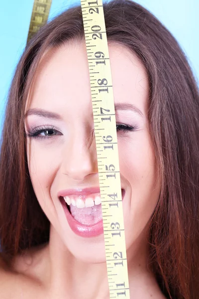 Beautiful young woman with measuring tape close up — Stock Photo, Image