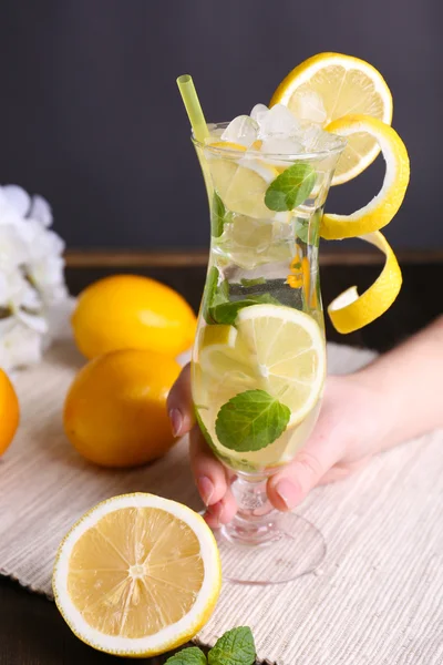 Glass of cocktail with lemon and mint on table on grey background — Stock Photo, Image