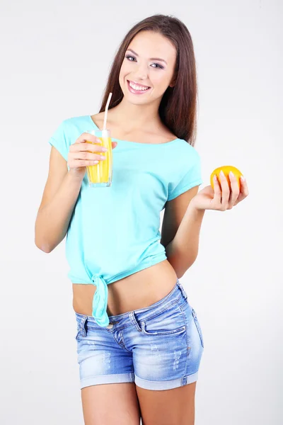 鲜榨果汁在灰色的背景上的漂亮女孩 — 图库照片