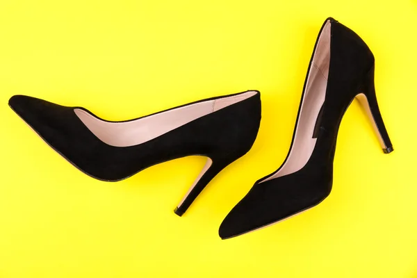 Beautiful black female shoes, on yellow background — Stock Photo, Image