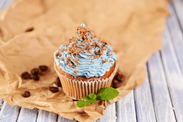 Tasty cupcake with butter cream, on color wooden  background — Stock Photo, Image