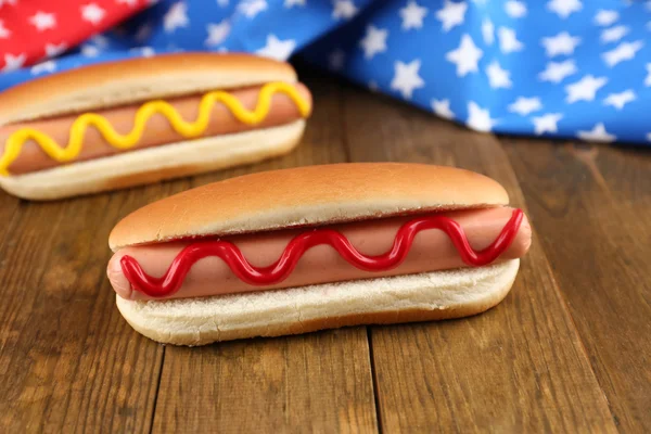 Cachorros-quentes saborosos na mesa de madeira — Fotografia de Stock