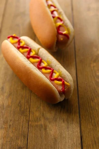 Tasty hot dogs on wooden table — Stock Photo, Image