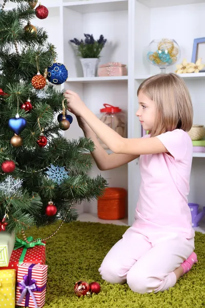 Lilla tjej dekorera julgran i rum — Stockfoto