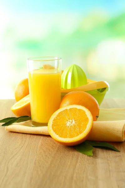 Zitruspresse und Orangen auf dem Tisch auf blauem Hintergrund — Stockfoto