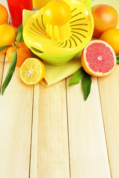 Citrus press and fruits on wooden background — Stock Photo, Image