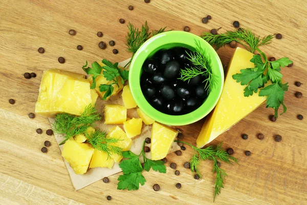 Queso parmesano, hierbas frescas y aceitunas sobre fondo de madera — Foto de Stock