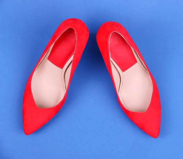 漂亮的红色女性鞋子，在蓝色背景上 — 图库照片