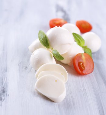ahşap masa üstünde domates ve fesleğen ile lezzetli mozzarella peyniri