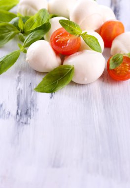 ahşap masa üstünde domates ve fesleğen ile lezzetli mozzarella peyniri