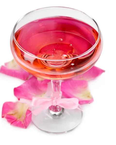 Composition avec vin mousseux rose en verre et pétales de rose isolés sur blanc — Photo
