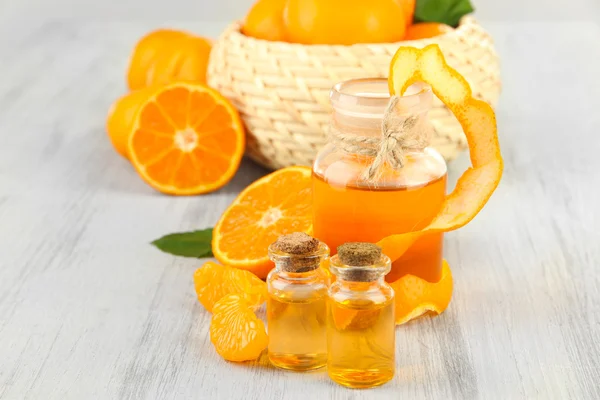 Tangerine essential oil and tangerines on wooden table — Stock Photo, Image