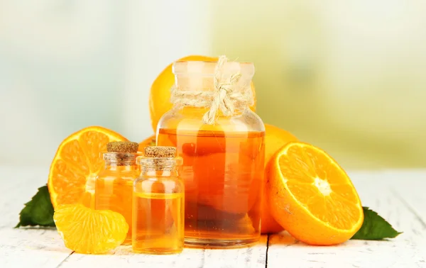 Tangerine essential oil and tangerines on wooden table — Stock Photo, Image