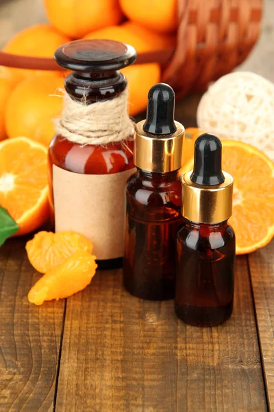 Tangerine essential oil and tangerines on wooden table — Stock Photo, Image