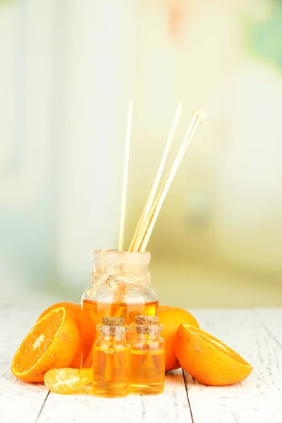 Aceite esencial de mandarina y mandarinas sobre mesa de madera —  Fotos de Stock