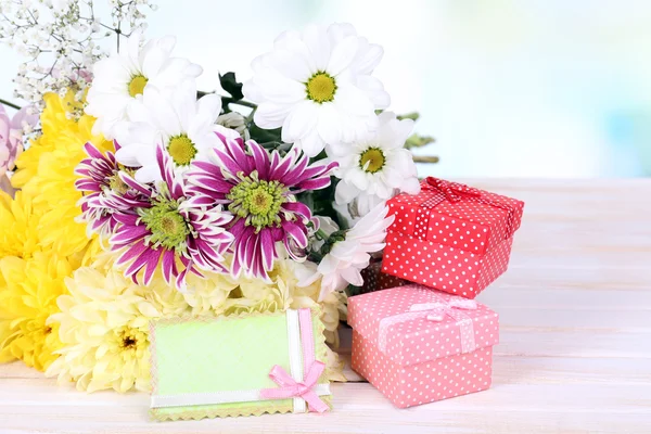 Hermosas flores de crisantemo en la mesa sobre fondo claro —  Fotos de Stock